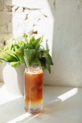 Summer coffee drink with ice cubes on the table with a sunbeam from the window.