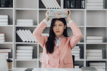 Young professional businesswoman working with stack of papers, searshing for the right file to work with.