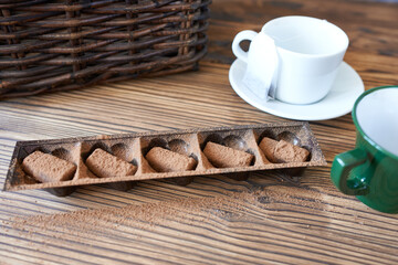 Chocolate truffles in a box on a wooden table.