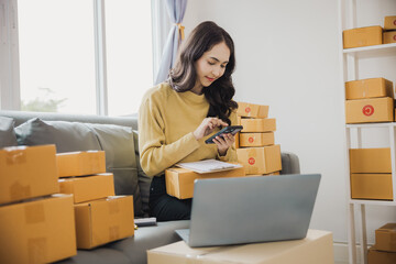 Small Business Entrepreneur SME Female Freelance Work From Home Happy young woman working BOX, tablet and laptop online, marketing, packaging, shipping, e-commerce concept..