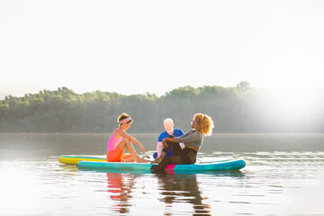 Three diverse friends enjoying their day and relaxing on SUP boards