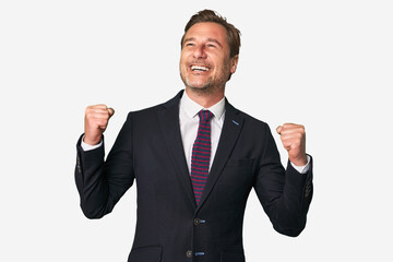 A middle-aged businessman isolated raising fist after a victory, winner concept.