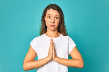 A young caucasian woman isolated praying, showing devotion, religious person looking for divine...