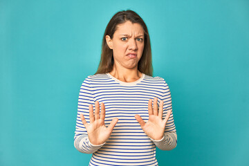 A young caucasian woman isolated rejecting someone showing a gesture of disgust.