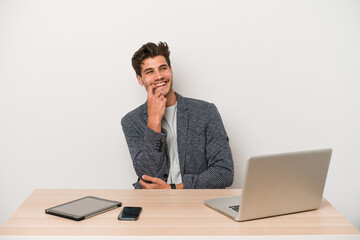 Young entrepreneur man working with a laptop isolated relaxed thinking about something looking at a copy space.