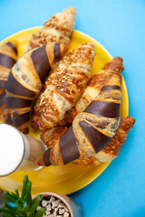 Chocolate croissants or croissant with nut crumbs on a plate. Breakfast on the table. Sweet baking dessert for coffee.