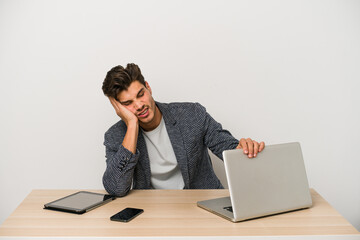 Young caucasian business entrepreneur man working with laptop, mobile phone and tablet