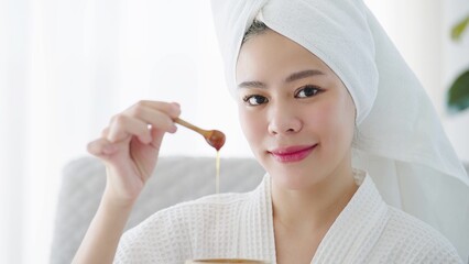 Close up face of beautiful young asian women in towel on head enjoying spa treatment with natural honey smiling to camera. Skin care concept