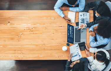 Panorama top view multiracial analyst team use BI dashboard display on laptop screen, analyzing financial data for strategic decision. Fintech analyzes marketing indicators. Concord