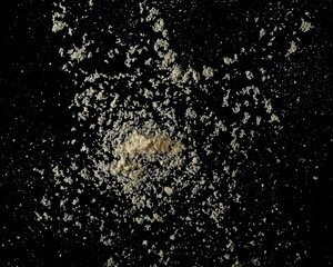 Almonds ground pile scattered isolated on black, top view, clipping path 