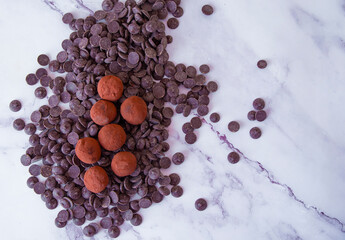 Chocolate truffles on a light marble background. View from above.