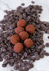 Chocolate truffles on a light marble background.