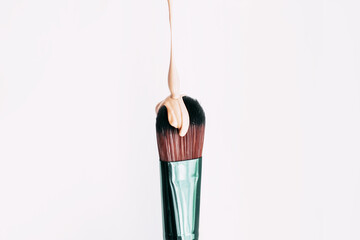 Makeup brush close-up with foundation on it.