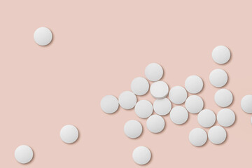 White medicine pills on pink background closeup.