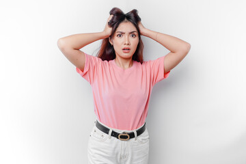 A portrait of an Asian woman wearing a pink t-shirt isolated by white background looks depressed