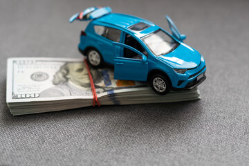 Money to buy or rent a car concept. Toy car with money cash
