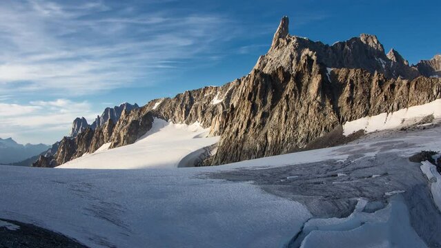 Rocky mountains with glacier in time lapse with thin clouds during sunset in summer, Dent du Geant, between Italy and France, Alps, Mont Blanc