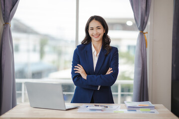 happy young woman excited at work Successful Asian businesswoman with laptop smartphone at work.