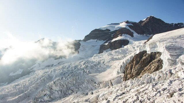Timelapse of a glacier with clouds and fog during sunset seen from Gnifetti Refuge in Monte Rosa range, Alps, Italy 