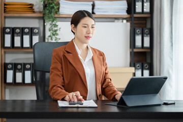 Women are using calculators to calculate office income.