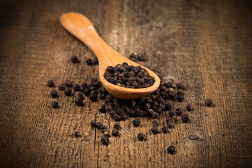 black pepper on wooden spoon
