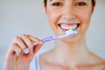 Toothpaste, toothbrush and woman brushing teeth in bathroom for health, happiness and wellness in morning. Girl, portrait and cleaning mouth or healthcare, dental care or oral hygiene, smile or home