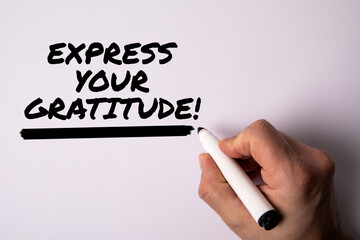 Express your gratitude. Male hand holding a black marker on a white background