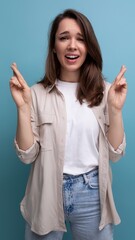 pretty young brunette female adult in casual shirt crossed her fingers