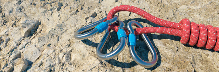 Mountaineering carabiner attached to a rope on a rock climbing trail 3d render