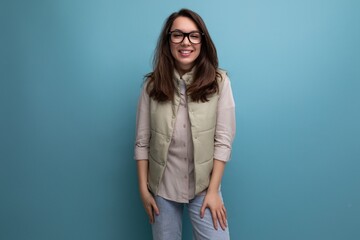 portrait of a well-groomed young brunette woman correcting her eyesight using glasses on a studio background with copy space