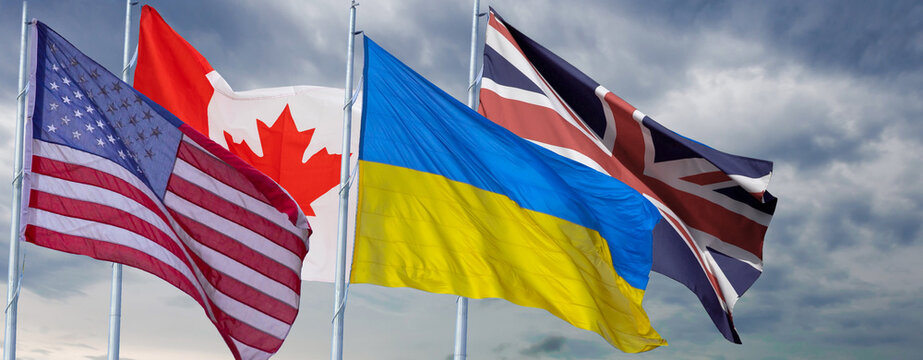 Small flags of different countries on table. Flags of Canada, American, United Kingdom, Ukraineon.