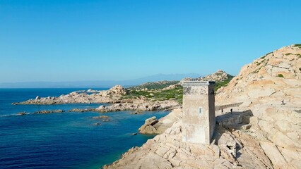 A Solitary Observer: Majestic Capu di Fenu Lighthouse Perched atop Rugged Cliffs Overlooking the...