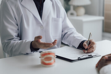 dentist and patient discussion about planned teeth treatment in dental clinic office room.