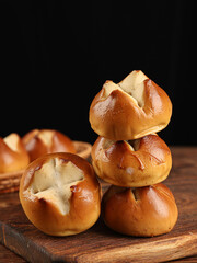 Laugenbrezel(Brezen),Lye bread in the shape of a peach with a cross cut in the middle, on a dark background