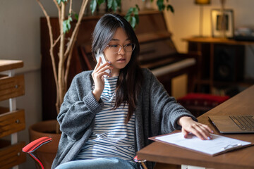 Serious young asian girl talking on the phone
