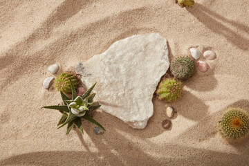 A broken stone displayed on sand background with some types of Cactus. Blank space for product or...