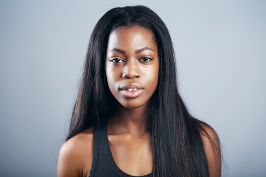 Model headshot, portrait and a confident black woman isolated on a studio background. Jamaica, posing and a young African girl with long hair for modeling profile with confidence on a backdrop