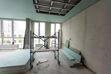 Workers assemble a suspended ceiling with drywall