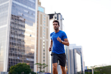 Sports, exercise and man running in the city for health, wellness or training for a marathon. Fitness, runner and male athlete doing an outdoor cardio workout for endurance or speed in an urban town. - obrazy, fototapety, plakaty