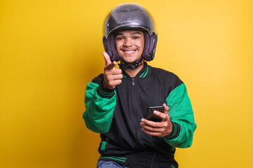 Asian online taxi driver motorbike wearing green jacket and helmet while holding smartphone...