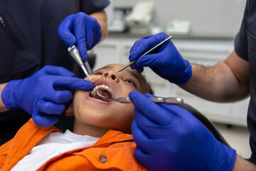 Close up of dentists working on teeth of a little boy