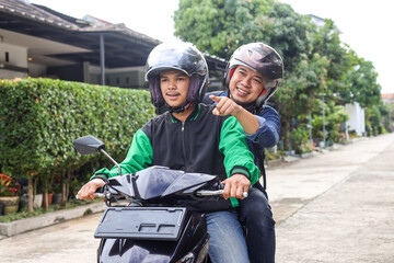 Online commercial motorcycle taxi driver taking his passenger to his destination