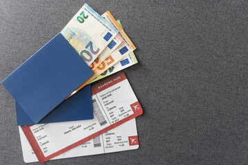 Two tickets for plane with passports on gray background