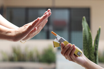 Woman hand refuses a cigarette. Quit smoking concept, World No Tobacco Day. - obrazy, fototapety, plakaty