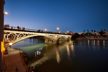 Fototapeta na wymiar Night view of the Isabel II bridge (Triana Bridge) at Sunset, Sevilla, Spain, Europe,.