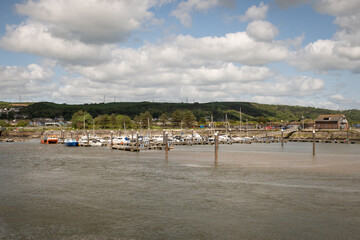 Harbour in South Wales fishing village Burry Port on sunny day while tide is out leaving boats stranded on sandy bottom