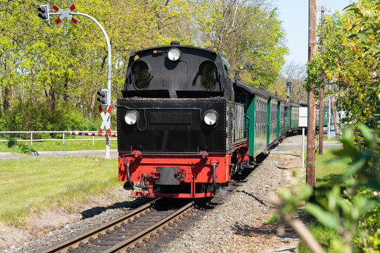 Schmalspurbahn "Rasender Roland" auf der Insel Rügen am Bahnübergang in Sellin