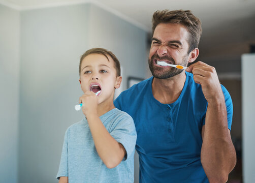 Happy, brushing teeth and father with son in bathroom for morning routine, bonding and dental. Oral hygiene, cleaning and smile with man and child in mirror of family home for self care and wellness