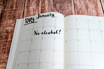 Dry January text in planner notebook on wooden background. 