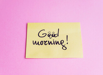 Good morning message on a sticky note on pink background 